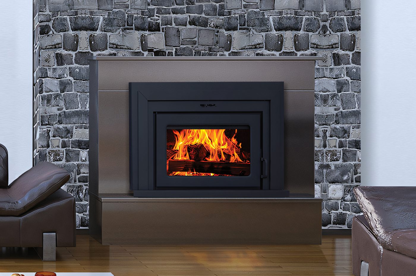 Un foyer encastrable Fusion dans une cheminée de moellons gris, fauteuils de cuir brun de chaque côté, le feu bien pris